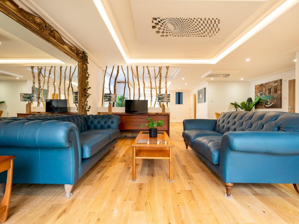 uma sala de estar com sofás azuis e uma mesa em Lux Light Spacious- Chilterns Pass the Keys em Amersham