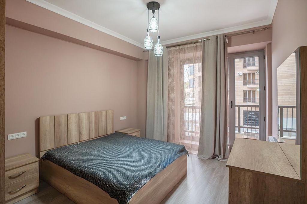 um quarto com uma cama e uma grande janela em New Kond appartment em Yerevan