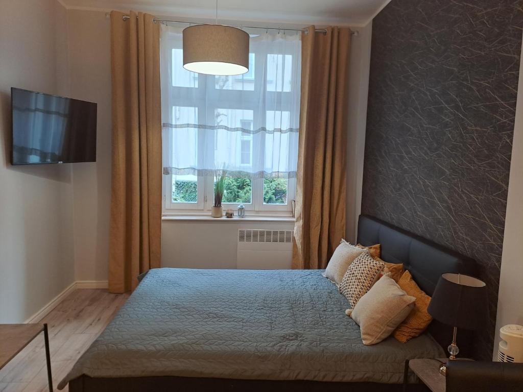 Schlafzimmer mit einem Bett und einem großen Fenster in der Unterkunft tylko Sopot - 200m do plaży, zapewniamy parking. in Sopot