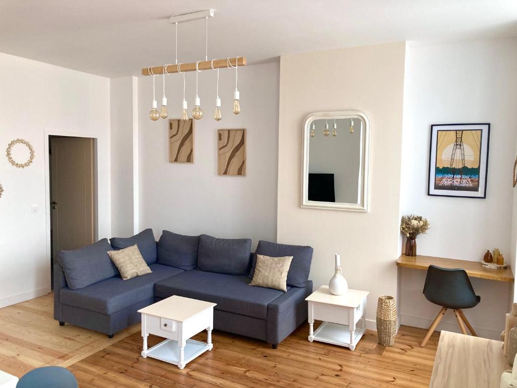 sala de estar con sofá azul y mesa en Beau T3 lumineux : La Couronne, en Rochefort
