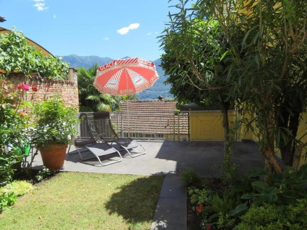 a patio with two chairs and an umbrella at Casa Speranza PT in Muralto