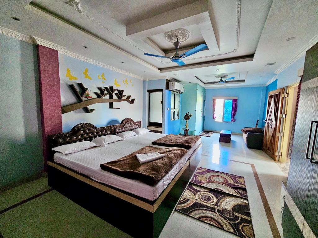 um quarto com uma cama grande e paredes azuis em Bobby Premium Residency em Puri