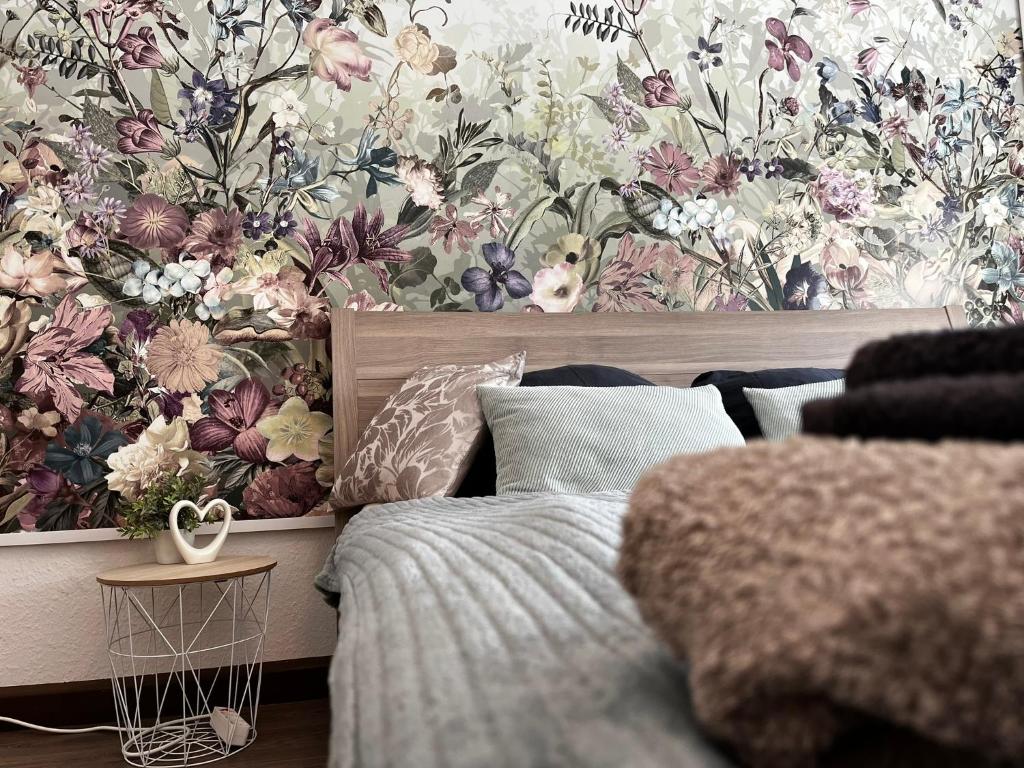 Schlafzimmer mit Blumentapete an der Wand in der Unterkunft Karli‘s Plätzchen in Gera