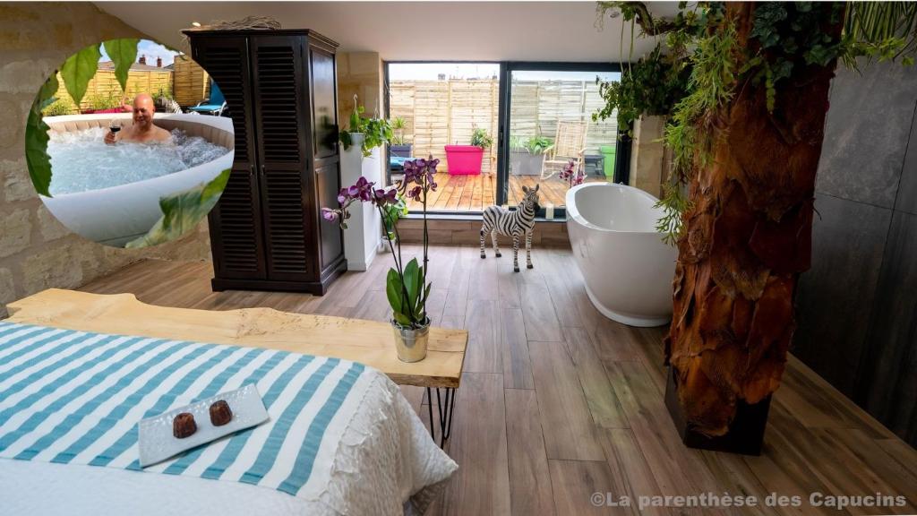 a bedroom with a tub and a bed and a tree at La Parenthèse des Capucins - Maison d'hôtes Bordeaux in Bordeaux