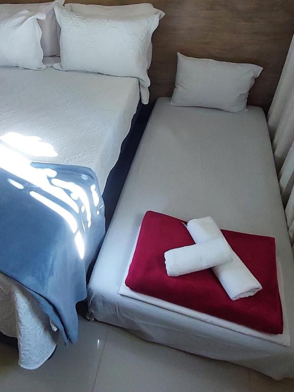 two beds in a room with a red and white towel at Tapindaré Hotel in Alto Paraíso de Goiás