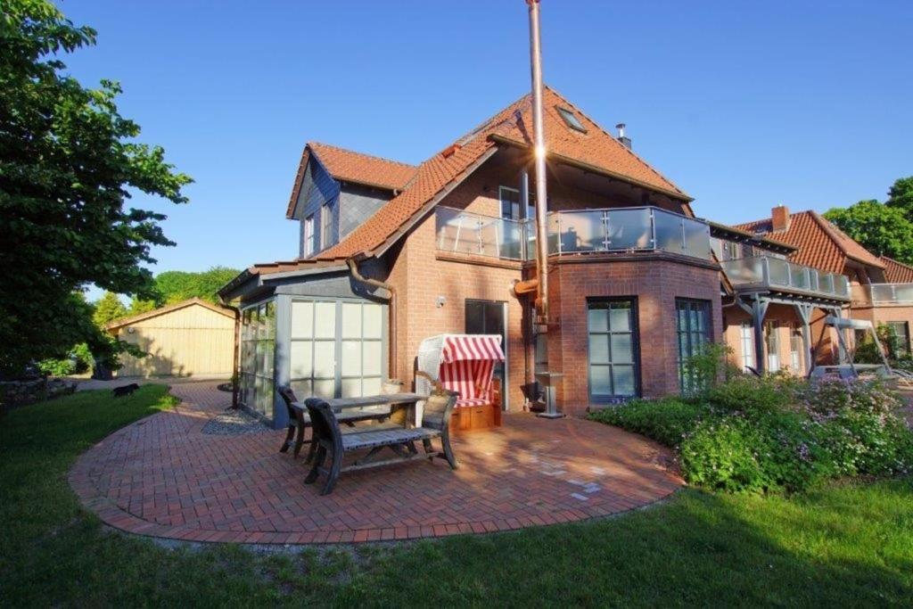 a house with a bench on a brick patio at Seegang- Fewo mit Grundstück in Flessenow