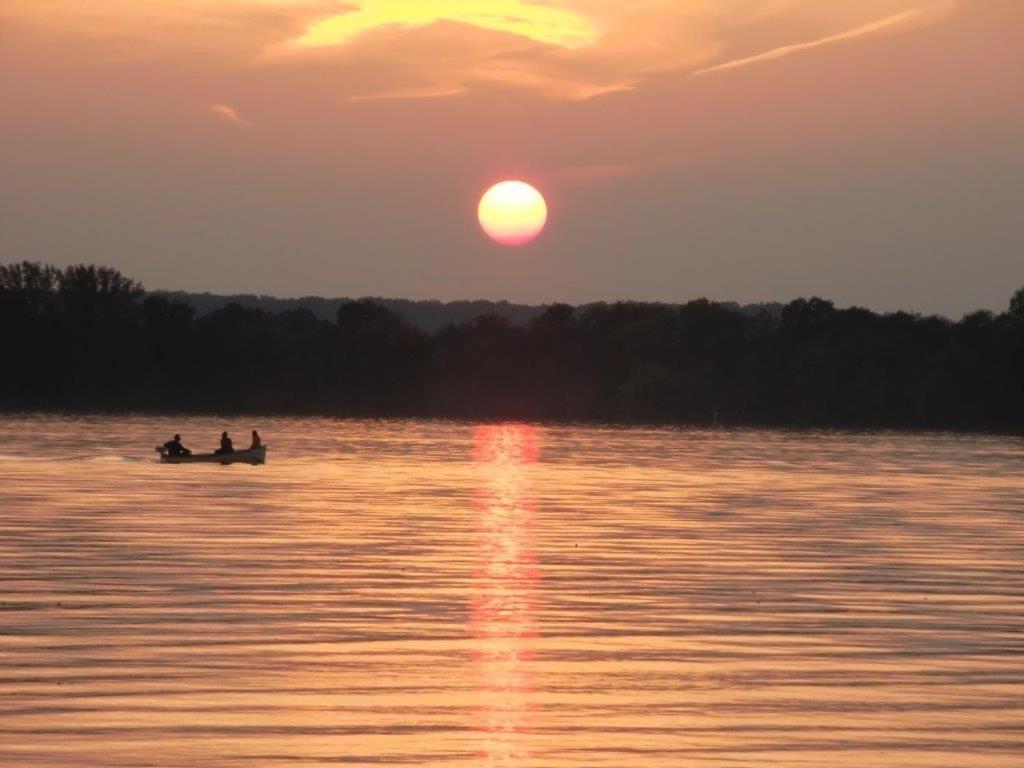 duas pessoas num barco num lago ao pôr-do-sol em FEWO Seegang em Flessenow