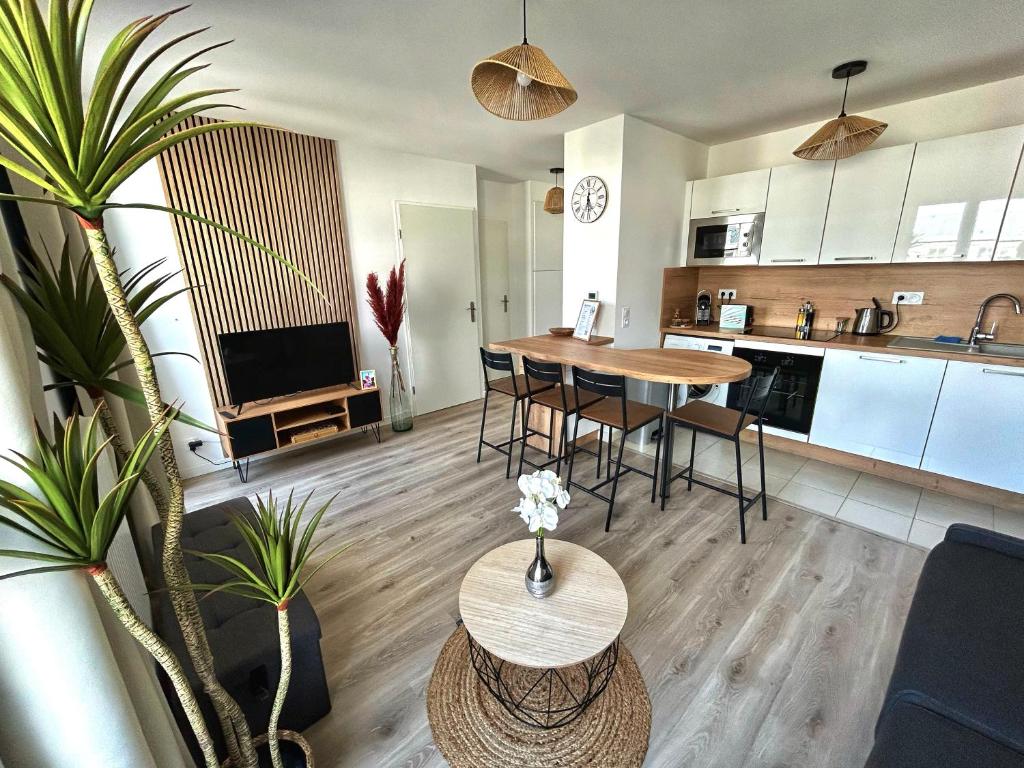 une cuisine et un salon avec une table et des chaises dans l'établissement Le Régence, terrasse, Serris Disney, à Serris