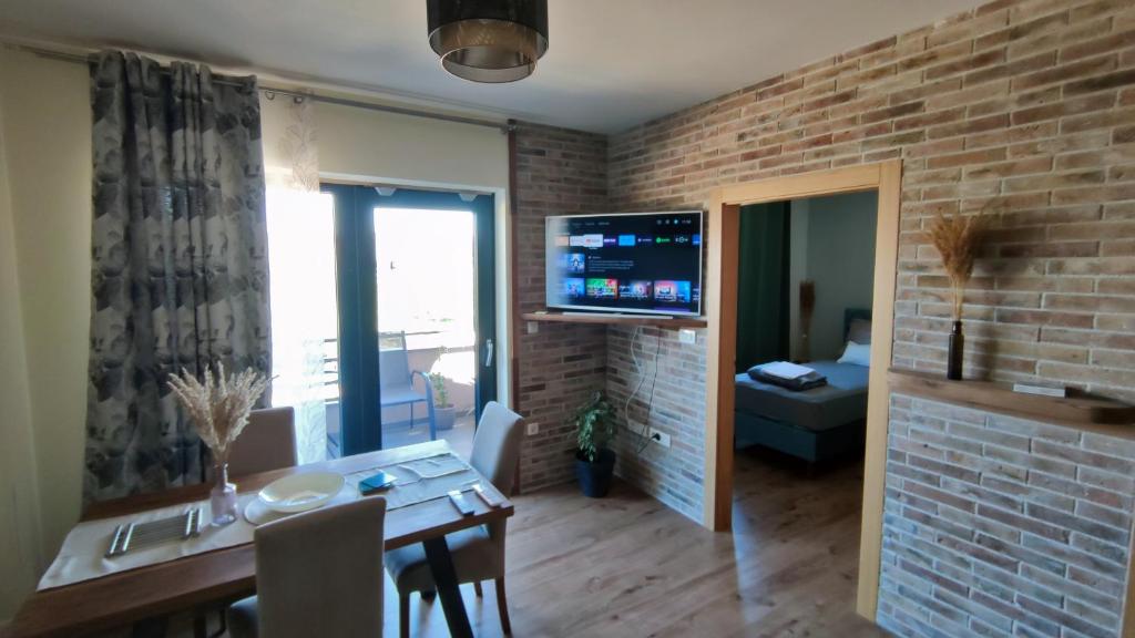 a living room with a dining table and a brick wall at Modern apartment in Biograd na Moru