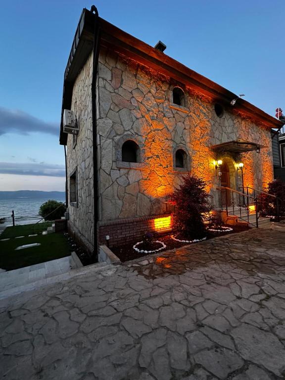 a stone building with the ocean in the background at Villa Atroa Gölevi in Orhangazi