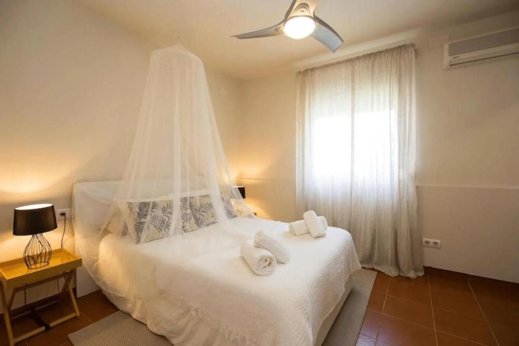 Un dormitorio con una cama blanca con toallas. en BANTI TARIFA, en Tarifa