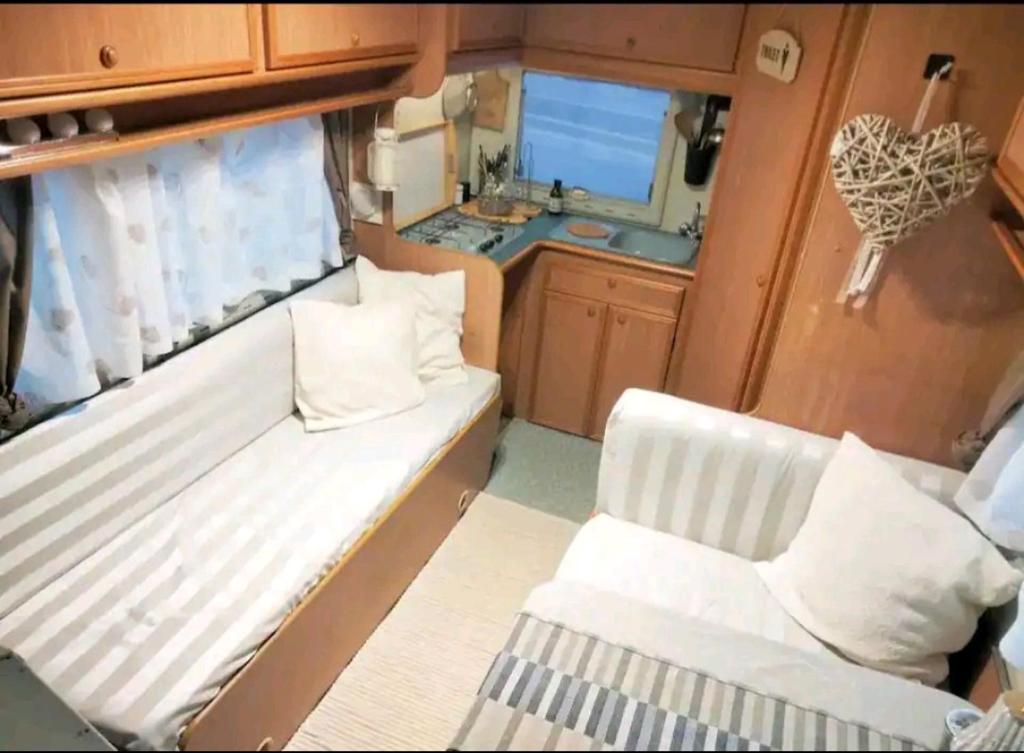 um pequeno quarto com um sofá branco e uma cozinha em Sweet Camper em Florença