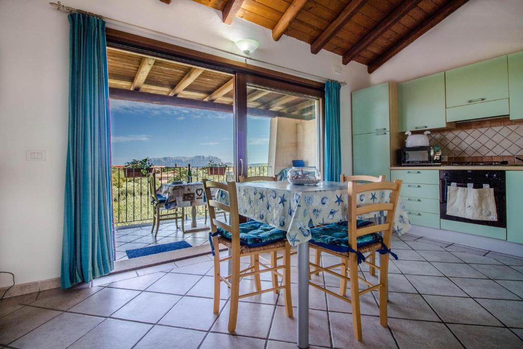 una cucina con tavolo e sedie e un balcone di Rovo house, Pittulongu, Olbia, Sardinia a Olbia