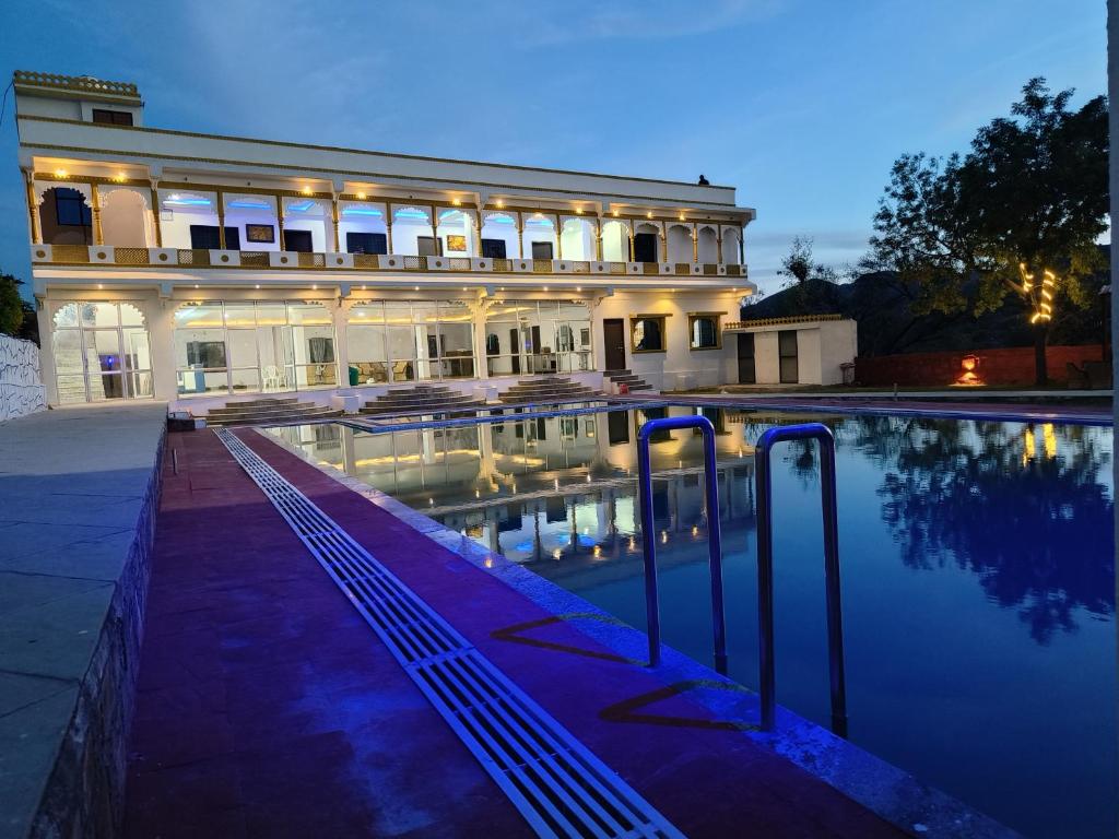 ウダイプールにあるMonkey Retreat Resortの大きな建物で、目の前にスイミングプールがあります。