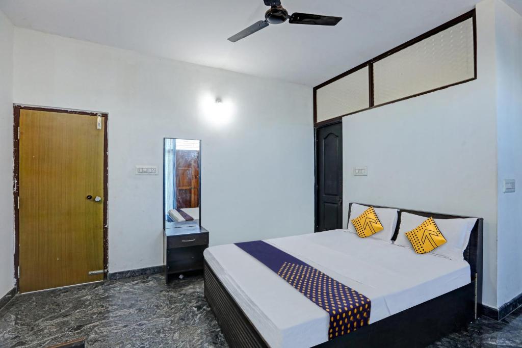 Un dormitorio con una cama con almohadas amarillas. en SPOT ON Sri Durga Residency Hd Kote, en Mysore