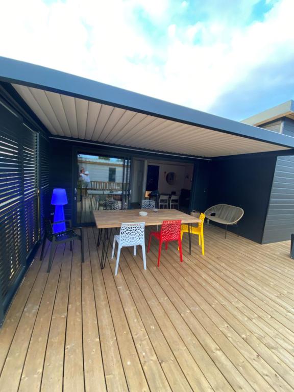 eine Terrasse mit einem Tisch und Stühlen darauf in der Unterkunft Cottage "SANS SOUCI" chaleureux à 150m de la plage in Jullouville-les-Pins