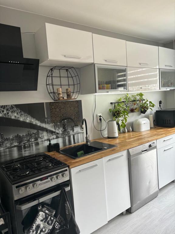 a kitchen with white cabinets and a stove top oven at Gdynia Apartament Torpedownia in Gdynia