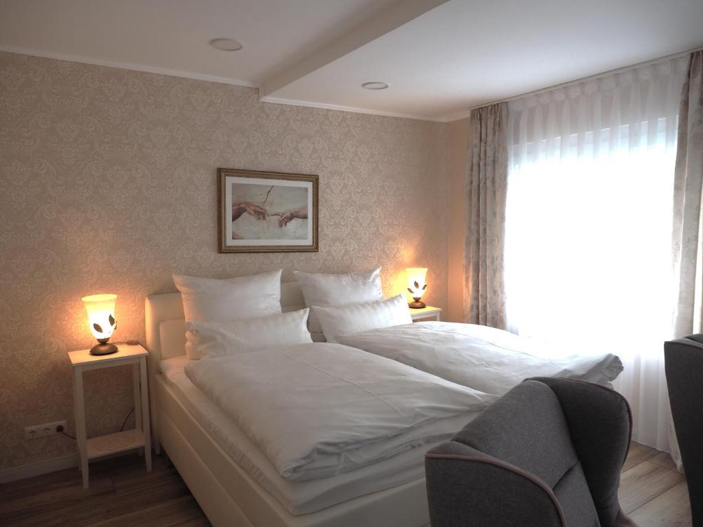 a bedroom with a large white bed with two lamps at Apartment Schlossblick - Top location in Idar-Oberstein