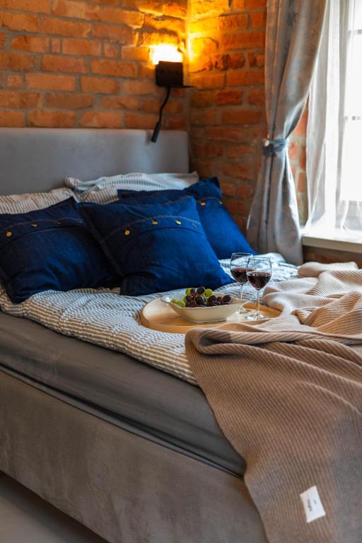 a bed with a plate of food and wine glasses at Reszel Art House in Reszel