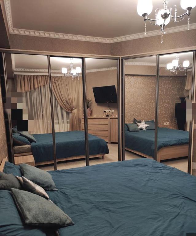 1 Schlafzimmer mit 2 Betten und einem Spiegel in der Unterkunft RentHUB apartment in Chişinău