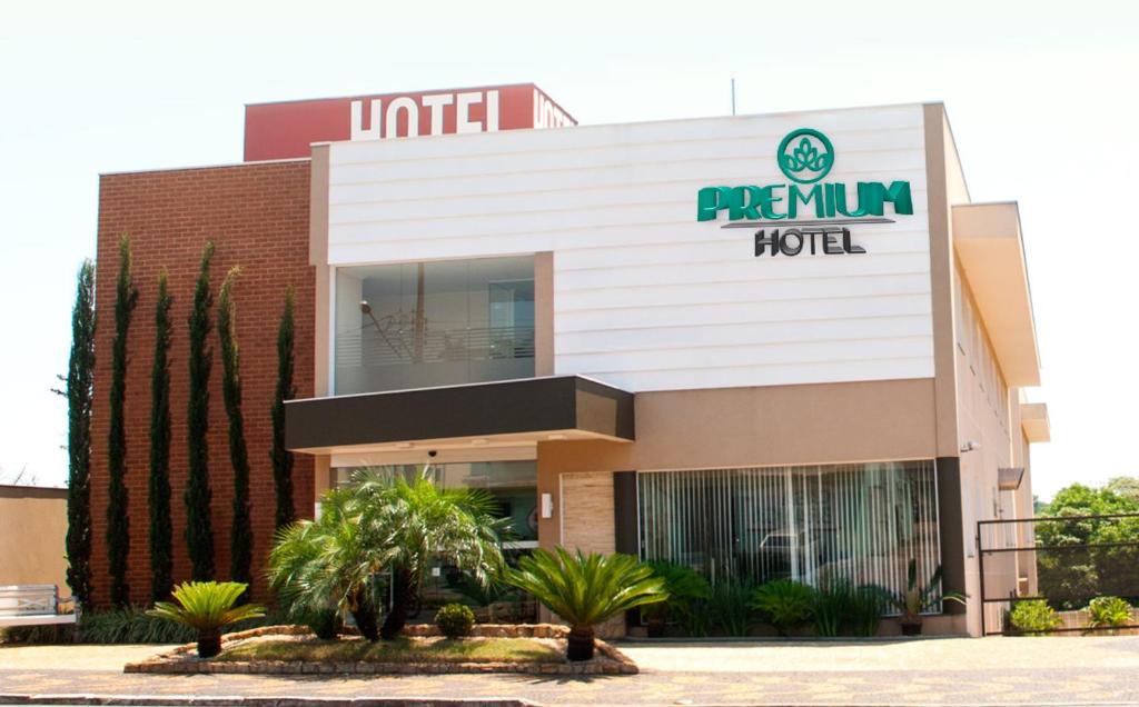 a hotel with palm trees in front of it at Hotel Premium Pirassununga in Pirassununga