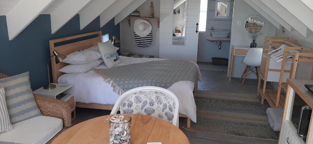 a bedroom with a bed and a table and a couch at Milk Thistle Loft & Studio apartments in Paternoster