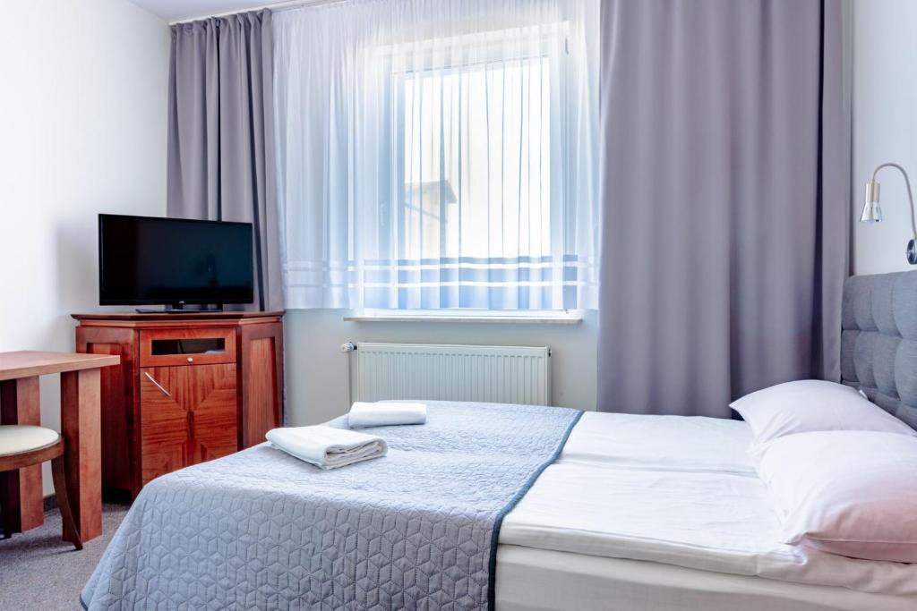 Habitación de hotel con cama y TV en Willa Kaszubska - Przepyszne Śniadanie na miejscu, en Jastrzębia Góra