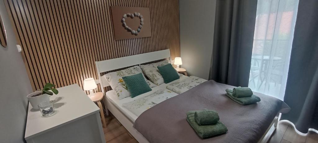 a bedroom with a bed with green pillows on it at Apartamenty Gościnne Idylla in Kudowa-Zdrój