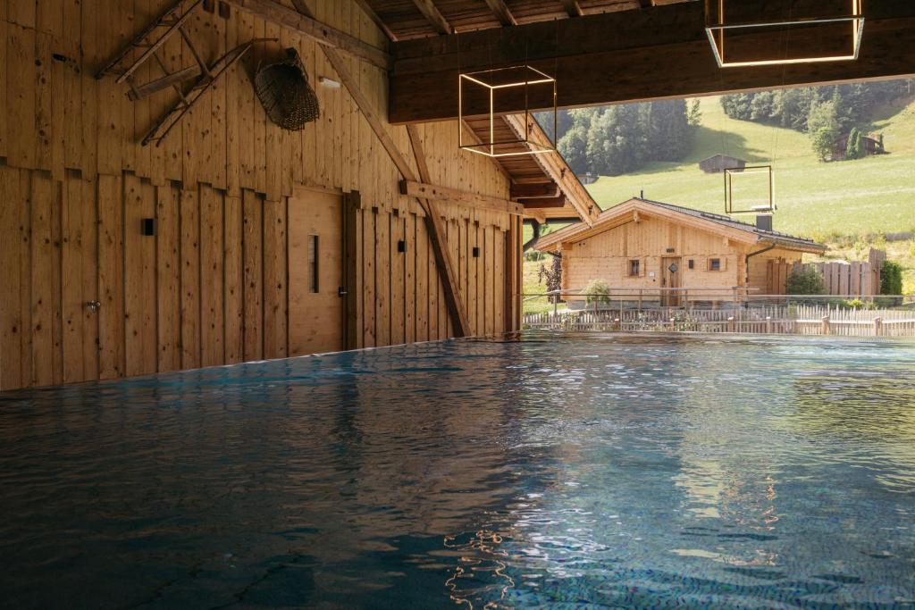 a swimming pool in a building with a basketball hoop at Hygna Chalets in Reith im Alpbachtal