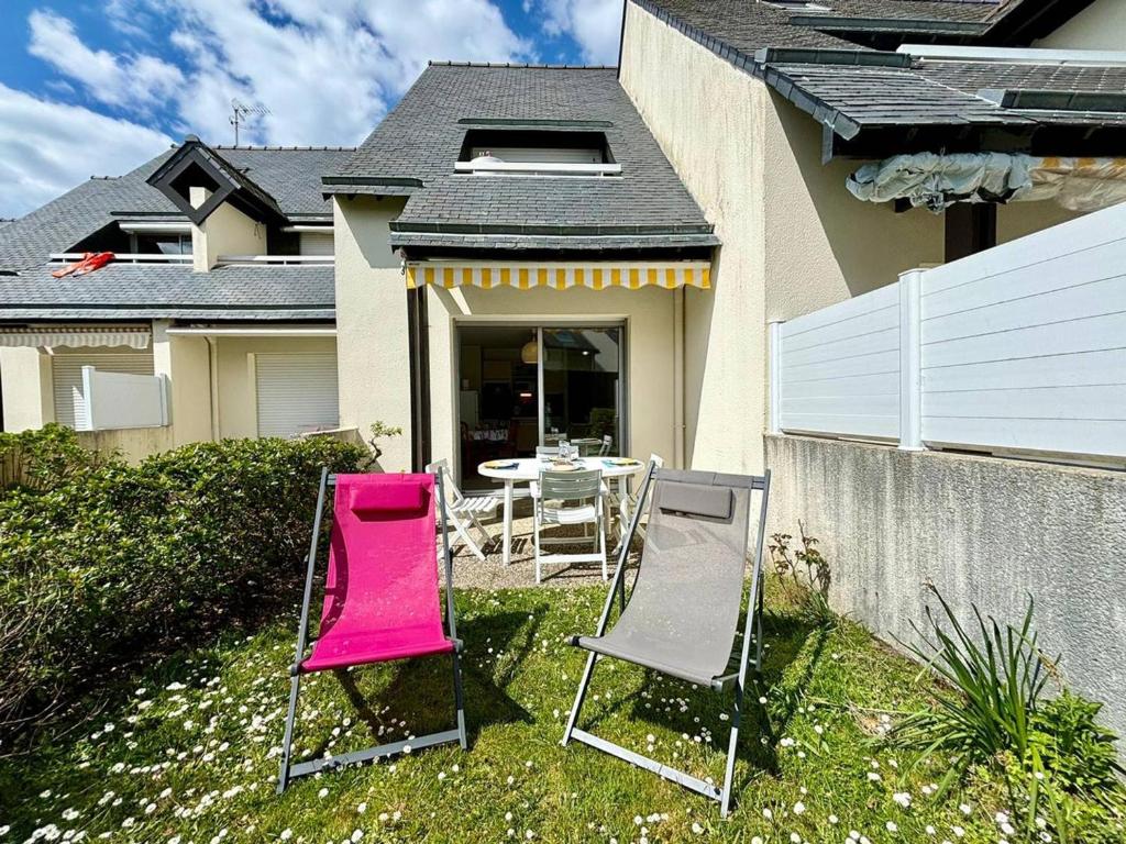 deux chaises et une table devant une maison dans l'établissement Carnac : Appartement T2 avec Terrasse - 4 Personnes - Animaux Acceptés - FR-1-377-15, à Carnac