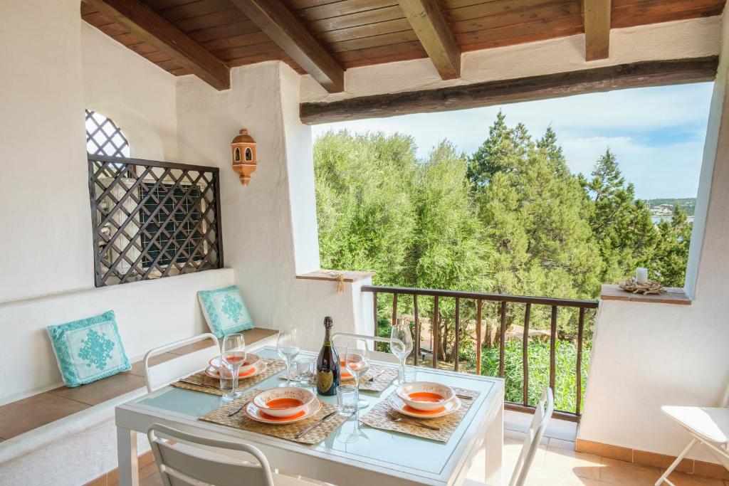 jadalnia ze stołem i krzesłami oraz balkonem w obiekcie [Poltu Qualtu 2 Min] Vista Mare e Piscina w mieście Liscia di Vacca