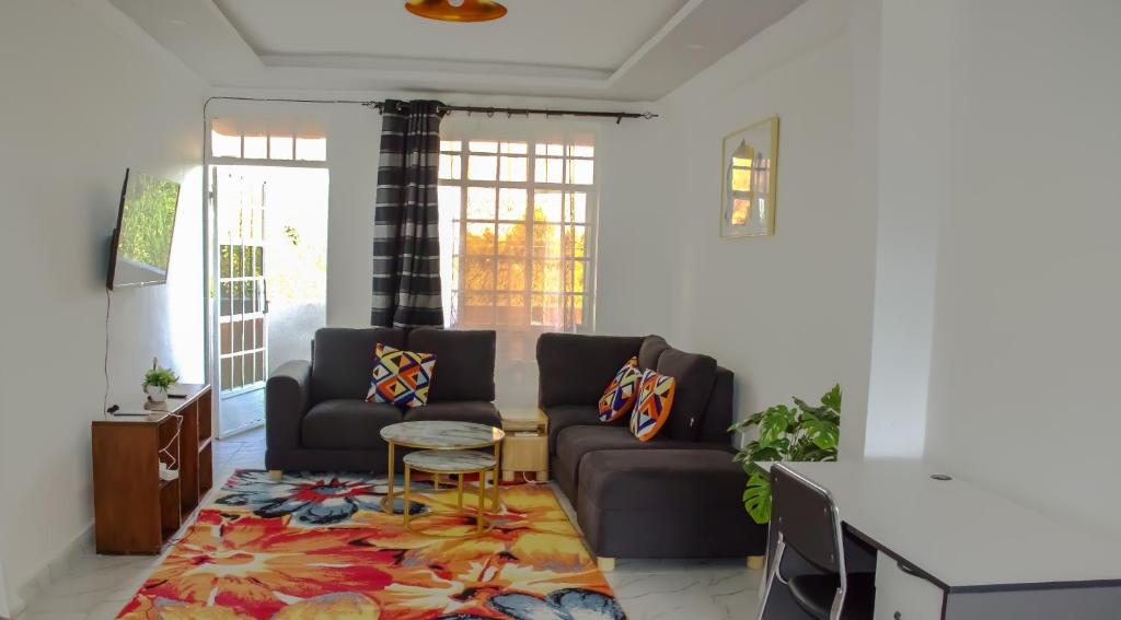 a living room with a couch and a table at One bedroom unit with wi-fi & parking in Nanyuki