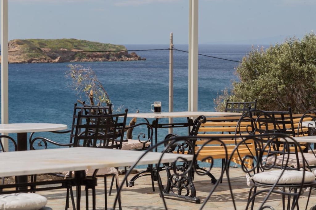 a table and chairs with a view of the water at Poseidon Apartments and Villas by the Sea in Sounio