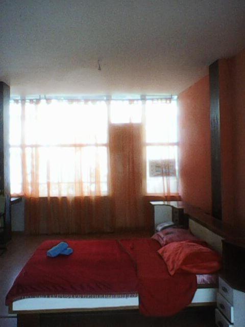 a bedroom with a bed with red sheets and two windows at Gene Kelly in Athens
