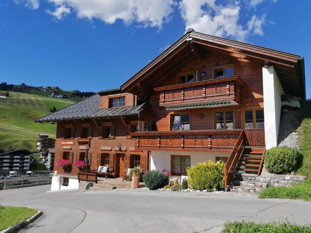 a large wooden house on a hill at Haus Schroefler in Lech am Arlberg