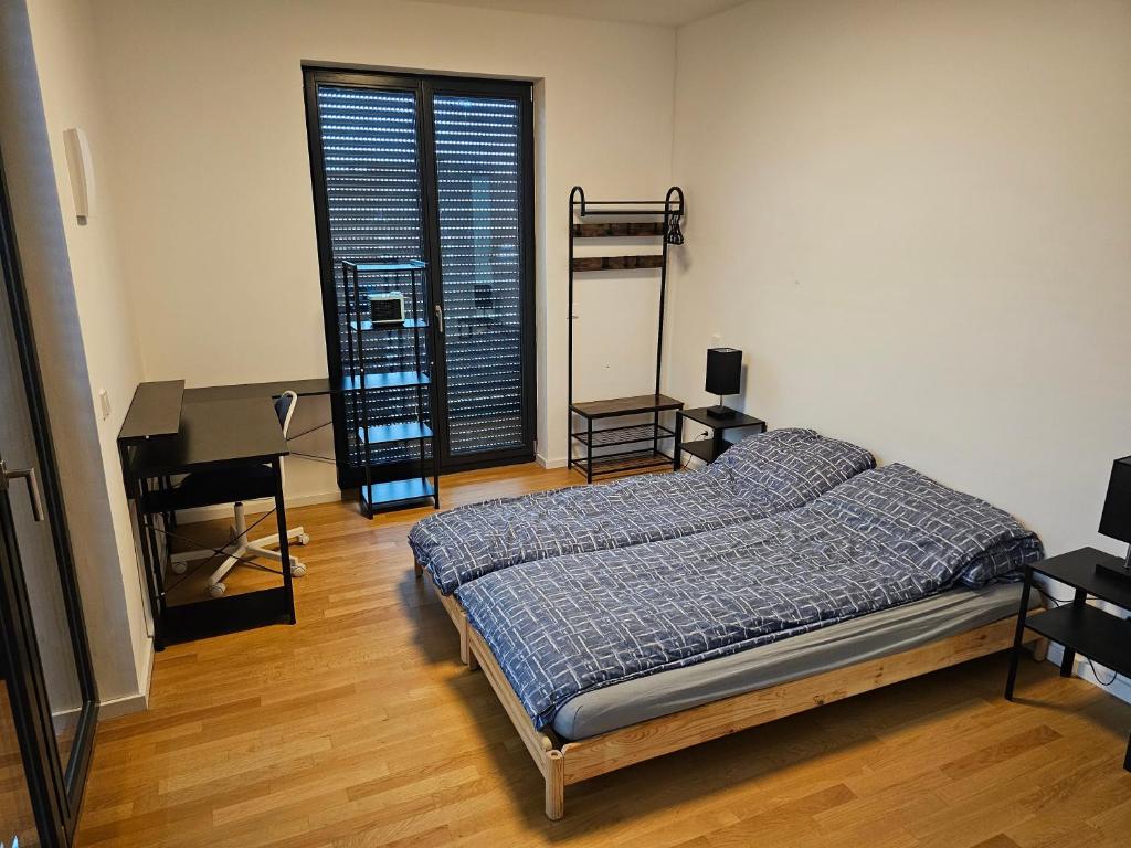 a bedroom with a bed and a desk and a piano at 3 rooms 2 bathrooms 2 toilets new apartment center of Düsseldorf underground parking space contactless self check-in in Düsseldorf