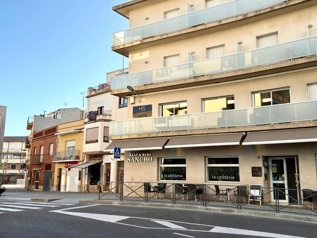 un edificio con balcone sul lato di una strada di Hotel Sancho a Hospitalet de l'Infant