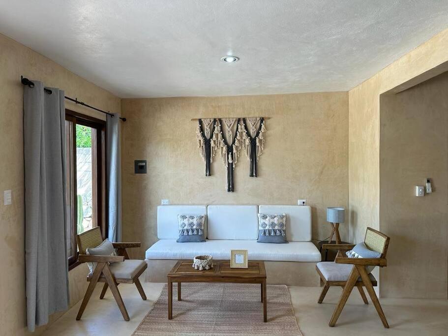 a living room with a white couch and a table at María Amor- Contemporary Maya Oasis in Valladolid
