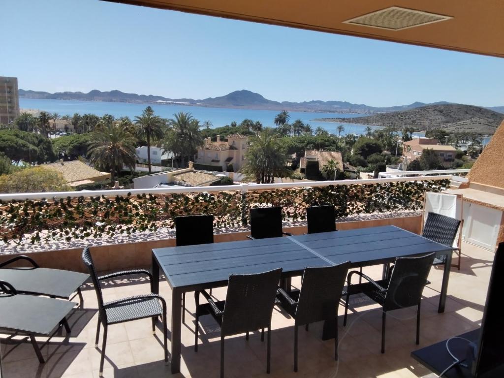 d'une table bleue et de chaises sur un balcon avec vue. dans l'établissement Ático de lujo, à La Manga del Mar Meno