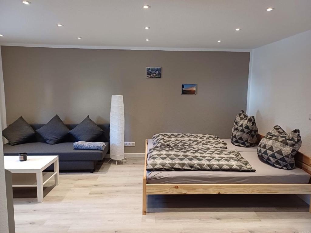 een slaapkamer met een bed en een bank bij Ferienwohnung Schwibbogen in Drebach