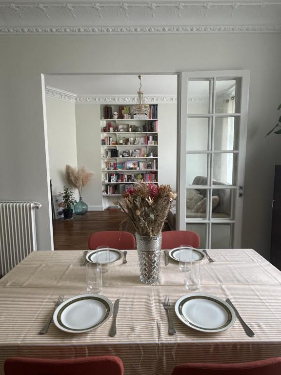 - une table à manger avec deux assiettes dans l'établissement Appartement parisien, à Paris