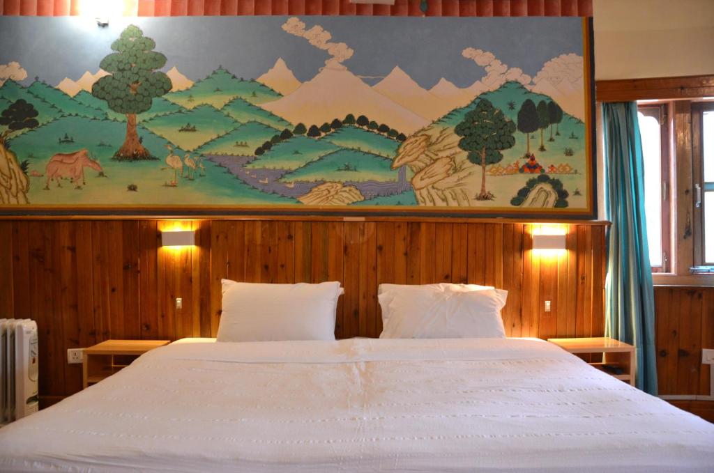 - une chambre avec un grand lit orné d'une peinture murale dans l'établissement Sinchula Villa, à Paro