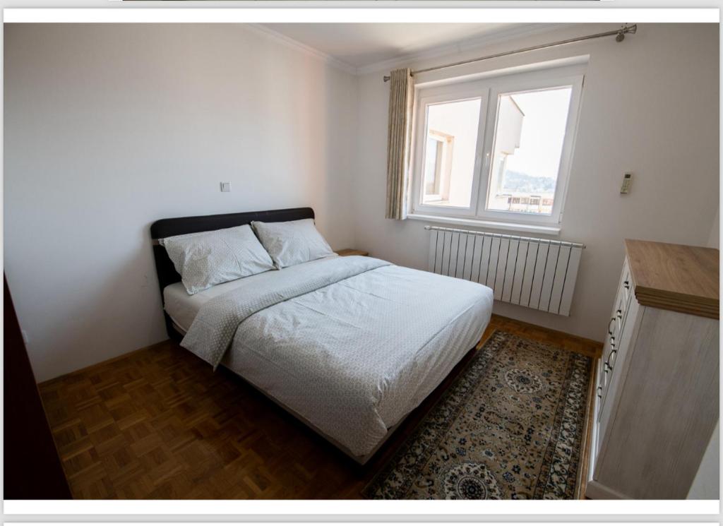 Dormitorio pequeño con cama y ventana en The View Apartments, en Ilijaš
