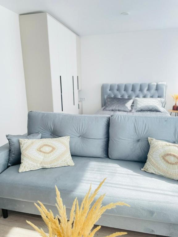 un divano blu in soggiorno con letto di MALU apartment Klaipėda City a Klaipėda