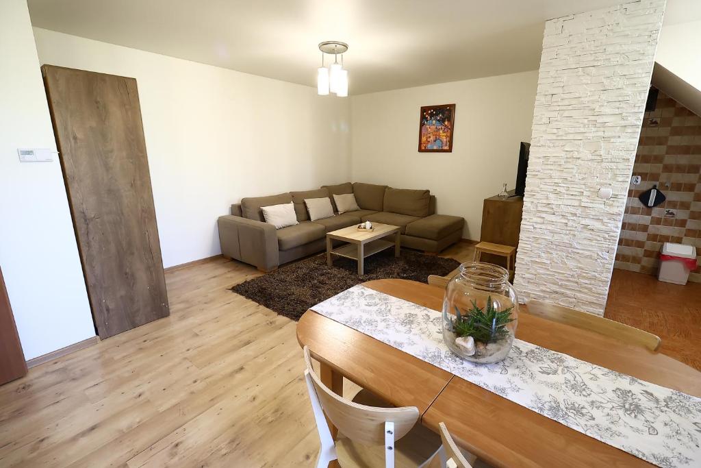 sala de estar con mesa y sofá en Rabczański Apartament, en Rabka-Zdroj