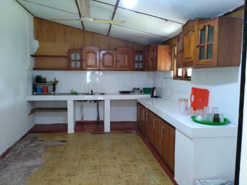 una cucina con armadi in legno e ripiani bianchi di Inara Holiday Home a Anuradhapura