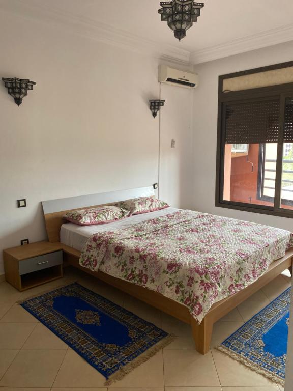 - une chambre avec un lit, une fenêtre et 2 tapis dans l'établissement Résidence Caprice Palace Hivernage, à Marrakech