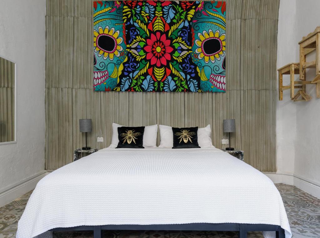 une chambre avec un grand lit avec un tableau au mur dans l'établissement CENTRO DE LA CIUDAD CASA PAXI ESTUDIO8, à Mérida