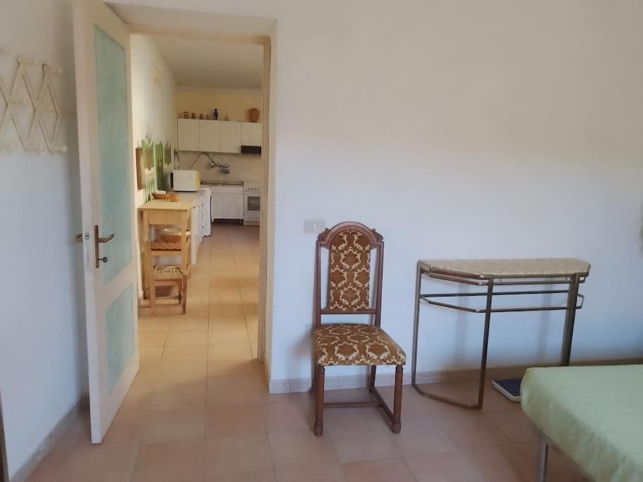 una camera con tavolo e sedia e una cucina di Casa vacanze Sa Rocchitta a Querce