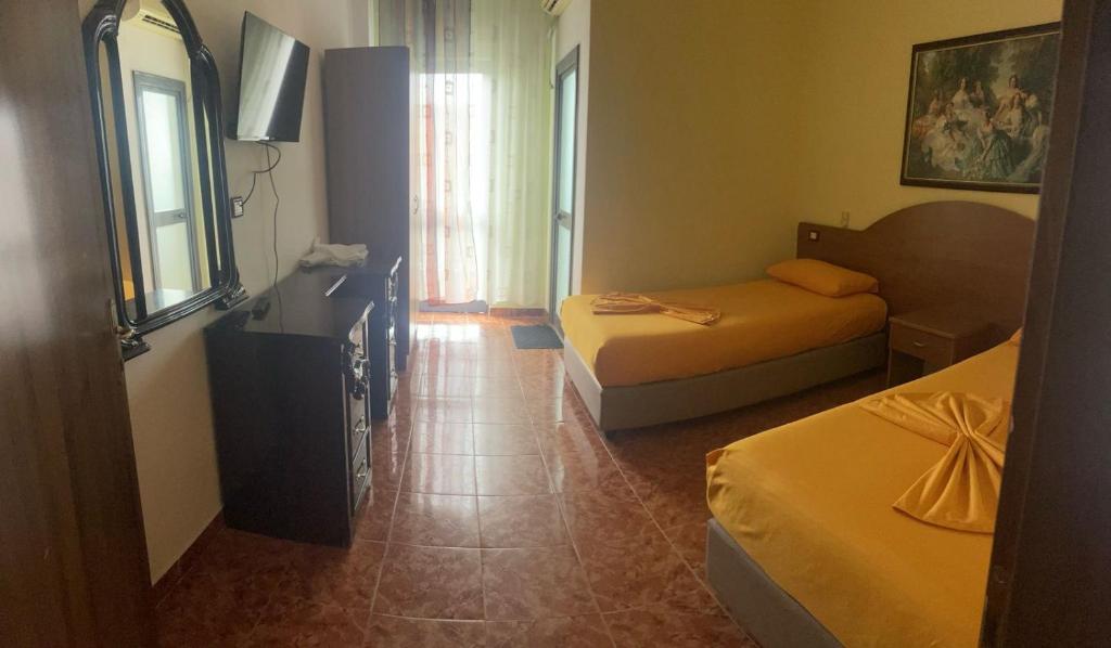 ein Hotelzimmer mit 2 Betten und einem TV in der Unterkunft Vila Megi in Golem